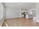 Open-concept living space with wood floors, leading to a modern kitchen with stainless steel appliances and a breakfast bar at 2038 Fishamble St, Fuquay Varina, NC 27526