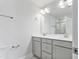 Bright bathroom featuring double sinks, modern fixtures, gray cabinets and a large mirror at 2042 Fishamble St # 32, Fuquay Varina, NC 27526
