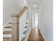 Hallway with hardwood floors, white walls, staircase, and an open doorway leading to another room at 2042 Fishamble St # 32, Fuquay Varina, NC 27526