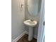 Powder room with pedestal sink and oval mirror at 2042 Fishamble St, Fuquay Varina, NC 27526