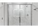 Modern shower featuring glass doors, white marble-patterned tile, and sleek chrome fixtures at 2042 Fishamble St # 32, Fuquay Varina, NC 27526