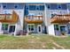 Townhome backyard featuring a green lawn, small patios, wood decks, and white fences at 2337 Bay Minette Sta # 553, Apex, NC 27502