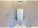 Close-up of half-bath showcasing a pedestal sink, oval mirror and modern fixtures at 2337 Bay Minette Sta # 553, Apex, NC 27502