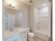 Well-lit bathroom featuring a white vanity, a large mirror, a toilet, and a tub with shower at 2337 Bay Minette Sta # 553, Apex, NC 27502