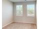 This bedroom is bright with neutral walls and carpet, and includes two windows with views of trees at 2337 Bay Minette Sta # 553, Apex, NC 27502