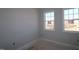 Empty bedroom with two large windows offering natural light and views of the surrounding landscape at 2337 Bay Minette Sta # 553, Apex, NC 27502