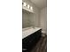 Bathroom showcasing sleek vanity with dark cabinetry and a large mirror at 566 John Stark Dr, Fuquay Varina, NC 27526