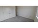 Light-filled bedroom featuring neutral carpeting, closet, and double doors at 566 John Stark Dr, Fuquay Varina, NC 27526