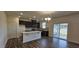 Open concept kitchen featuring a center island, stainless steel appliances, and sliding glass doors at 566 John Stark Dr, Fuquay Varina, NC 27526