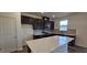 Modern kitchen featuring a center island, stainless steel appliances, and dark cabinetry at 566 John Stark Dr, Fuquay Varina, NC 27526