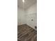 Well-lit laundry room includes overhead shelving and wood-look flooring at 566 John Stark Dr, Fuquay Varina, NC 27526