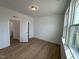 Bright bedroom with wood-look flooring, a large window, and an ensuite bathroom at 57 Bering Cir, Angier, NC 27501