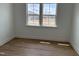 Bright bedroom with wood-look flooring and a window overlooking the neighborhood at 57 Bering Cir, Angier, NC 27501