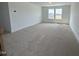 Bright bonus room featuring neutral carpet, white trim and a double window at 57 Bering Cir, Angier, NC 27501