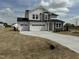 Inviting two-story home featuring a spacious three-car garage and neutral-colored exterior at 57 Bering Cir, Angier, NC 27501