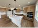 Open kitchen featuring an island, stainless steel appliances, and modern light fixtures at 57 Bering Cir, Angier, NC 27501