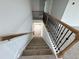 Carpeted staircase with stained handrail and black iron balusters at 57 Bering Cir, Angier, NC 27501
