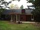 Backyard view of a one-story house with brick chimney, patio, and decorative garden trellis at 301 Briarcliff Dr, Dunn, NC 28334