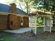 Backyard view featuring a brick chimney, patio, steps, and a garden trellis with foliage at 301 Briarcliff Dr, Dunn, NC 28334