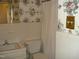 Modest bathroom featuring floral wallpaper and a standard toilet and sink at 301 Briarcliff Dr, Dunn, NC 28334