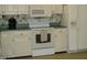 Traditional kitchen with white appliances, cabinets and floral wallpaper at 301 Briarcliff Dr, Dunn, NC 28334