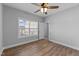Cozy bedroom with wood-look flooring, ceiling fan, and natural light from the window at 5554 Lake Vista Ct, Rocky Mount, NC 27803