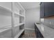 Functional laundry room with granite countertop, sink, dark cabinets, and open shelving for storage at 5554 Lake Vista Ct, Rocky Mount, NC 27803