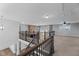 Open living room featuring a stone fireplace and wrought iron railing on the second floor overlook at 5554 Lake Vista Ct, Rocky Mount, NC 27803