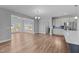 Open living space with wood floors, kitchen cabinets and stainless steel appliances, with access to sunroom at 5554 Lake Vista Ct, Rocky Mount, NC 27803