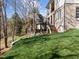 Backyard of home with multi-tiered patios, lawn and natural landscaping in the background at 126 E Drewry Ln, Raleigh, NC 27609