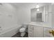 White bathroom with subway tile, a tub, a sink with chrome fixtures, and gray floors at 126 E Drewry Ln, Raleigh, NC 27609