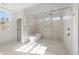 Luxurious bathroom featuring a soaking tub inside a seamless glass shower, tiled floor, and a large window at 126 E Drewry Ln, Raleigh, NC 27609