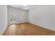 Bright bedroom with hardwood floors, white walls, and natural light from a glass exterior door and a window at 126 E Drewry Ln, Raleigh, NC 27609