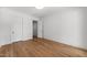 Bedroom with white walls, hardwood floors, two white doors and a door partially open revealing a bathroom at 126 E Drewry Ln, Raleigh, NC 27609