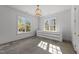 Bonus room with two windows, grey concrete floors, modern chandelier and a white cabinet at 126 E Drewry Ln, Raleigh, NC 27609