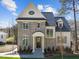 Charming two-story brick home featuring gray shutters, a covered entry, and manicured landscaping at 126 E Drewry Ln, Raleigh, NC 27609
