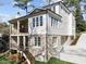 Stunning rear view of the two-story home, featuring an elevated deck and a blend of brick and light siding at 126 E Drewry Ln, Raleigh, NC 27609