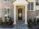 Stunning entryway with white columns, dark wood door, slate tile, and manicured landscape at 126 E Drewry Ln, Raleigh, NC 27609