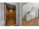 Hallway featuring a wood-paneled elevator and staircase with white railing and hardwood steps at 126 E Drewry Ln, Raleigh, NC 27609