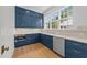 This kitchen features blue cabinets, stainless steel appliances and marble countertops at 126 E Drewry Ln, Raleigh, NC 27609