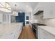 White kitchen featuring a large island, stainless appliances, and white cabinetry with marble countertops at 126 E Drewry Ln, Raleigh, NC 27609