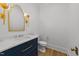 Elegant powder room with a navy blue vanity, marble countertop, and decorative mirror and sconces at 126 E Drewry Ln, Raleigh, NC 27609