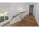Elegant staircase featuring wood floors, a modern railing, and a decorative chandelier at 126 E Drewry Ln, Raleigh, NC 27609