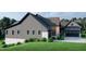 Side view showcasing the home's gray siding, stone foundation and landscaping at 143 High Ridge Ln, Pittsboro, NC 27312