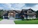 Modern farmhouse exterior with dark siding, stone accents, and a large covered porch at 143 High Ridge Ln, Pittsboro, NC 27312