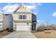 Two-story house with beige siding, stone accents, and a two-car garage at 182 Ford Meadows Dr, Garner, NC 27529