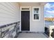 Dark brown front door with sidelights, stone accents and a covered porch at 182 Ford Meadows Dr, Garner, NC 27529