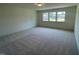 Bright bedroom with neutral carpet and large windows offering plenty of natural light at 23 Quail Pt Cir, Clayton, NC 27520