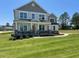 Charming two-story home featuring a covered front porch, manicured lawn, and stone accents at 23 Quail Pt Cir, Clayton, NC 27520