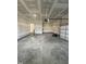 Two-car garage with painted walls, concrete flooring, and entry door to interior staircase at 23 Quail Pt Cir, Clayton, NC 27520